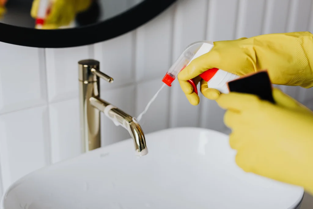 Professional cleaner detailing a faucet with gloves in College Park, GA