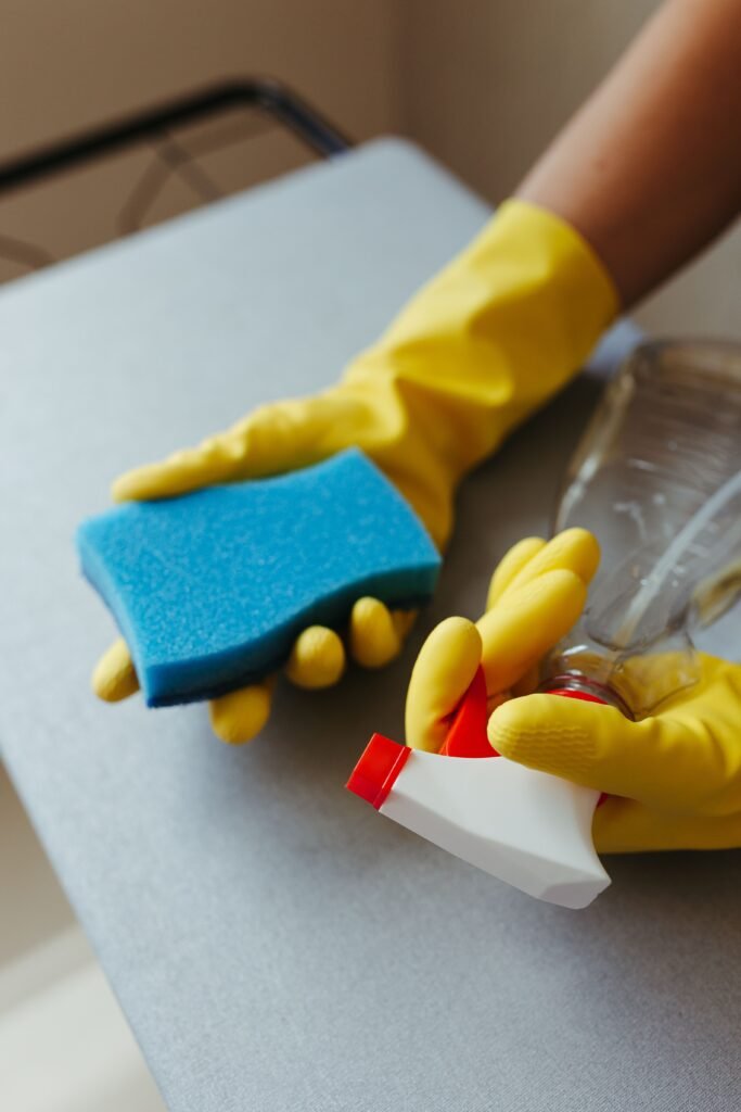 Gloved hand disinfecting a doorknob in a Riverdale GA home during flu season