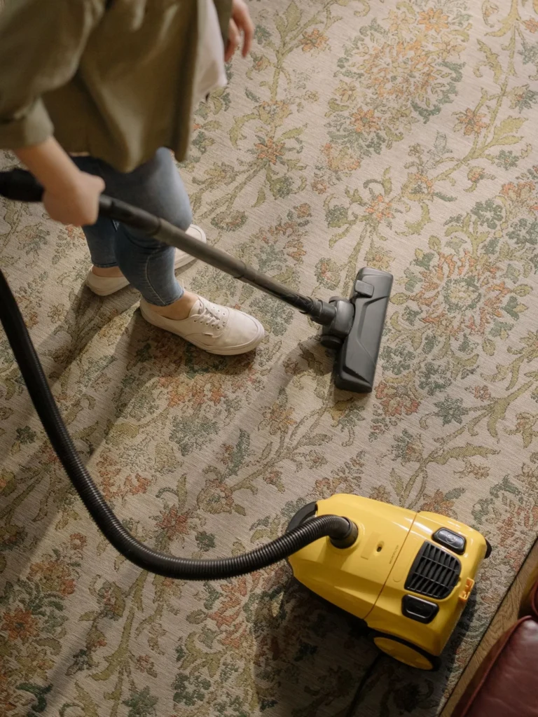 Professional cleaner vacuuming a living room in Riverdale, GA