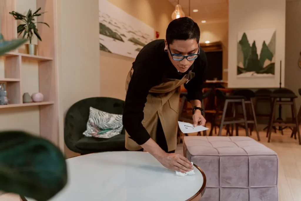 Cleaner wiping tables in a commercial space