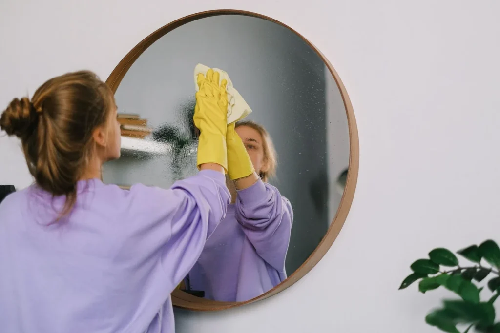 Professional cleaner wiping a mirror and glass surface streak-free
