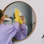 Professional cleaner wiping a mirror and glass surface streak-free