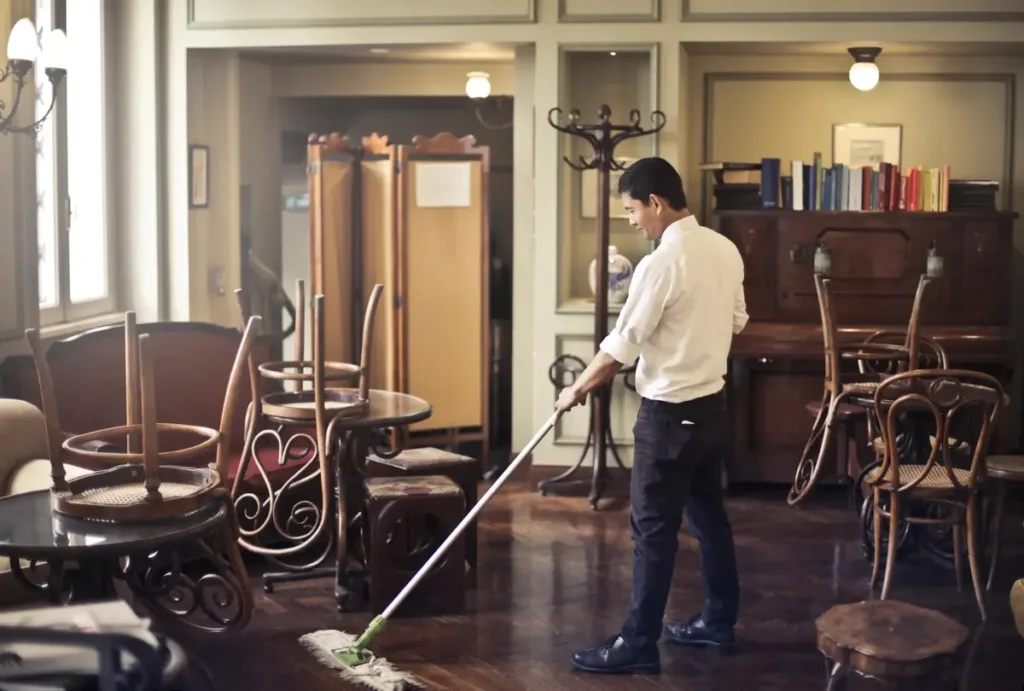 Professional vacuuming a living room floor before guests arrive